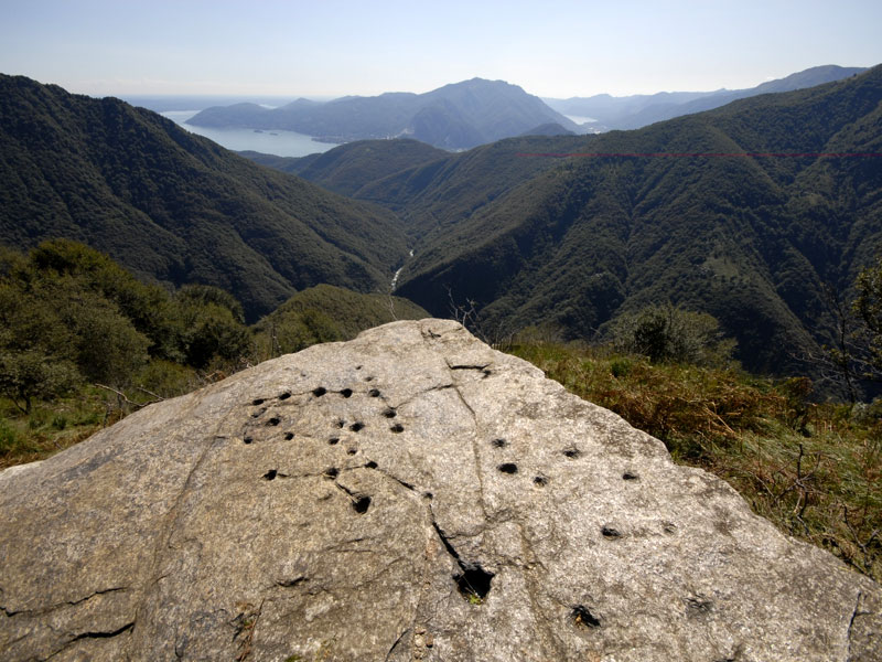 Boulder with cup and ring marks and Maggiore Lake in the background